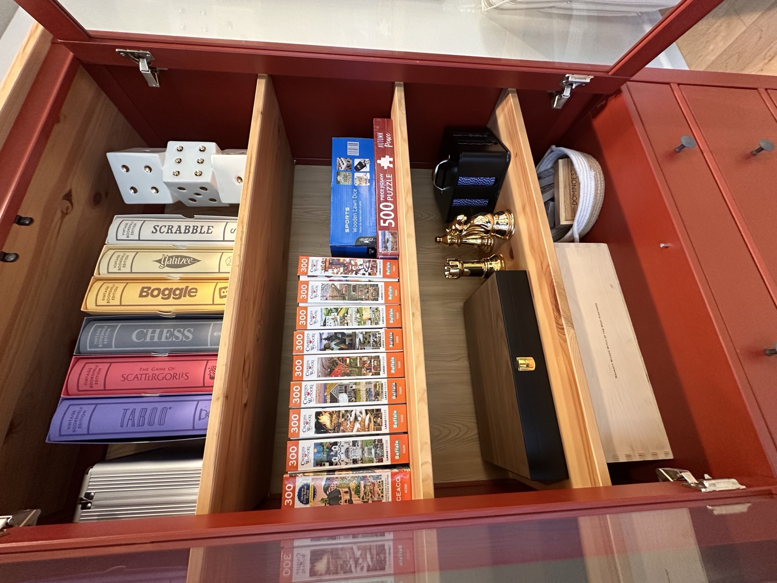 Cabinet stocked with board games, puzzles, chess, and dominoes for activities