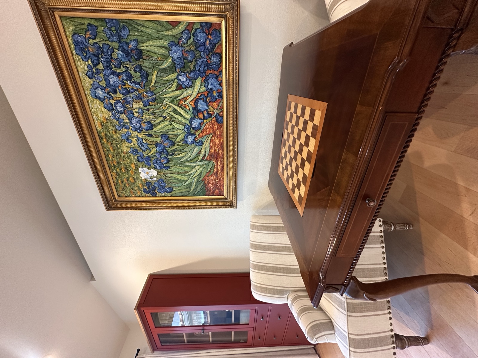 Game table with a chess and checkers board beside a framed painting
