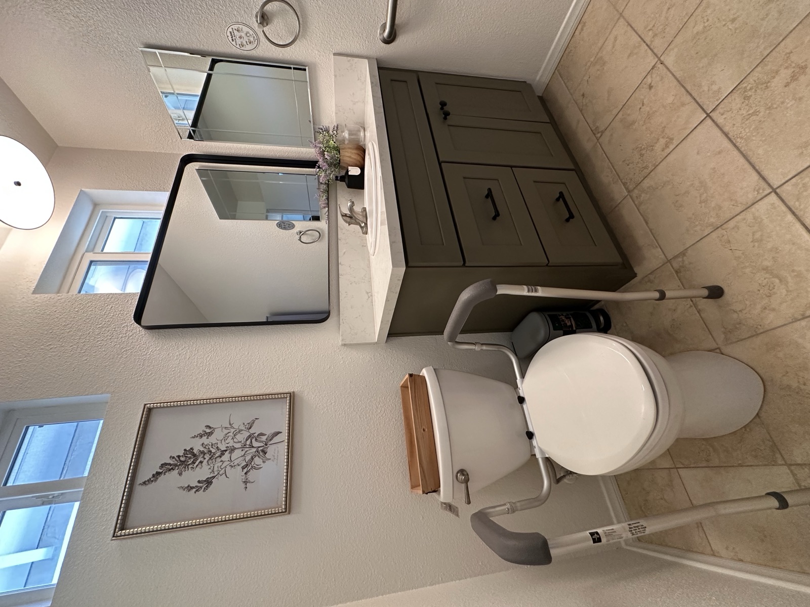 Accessible bathroom with a raised toilet safety frame and grab bar