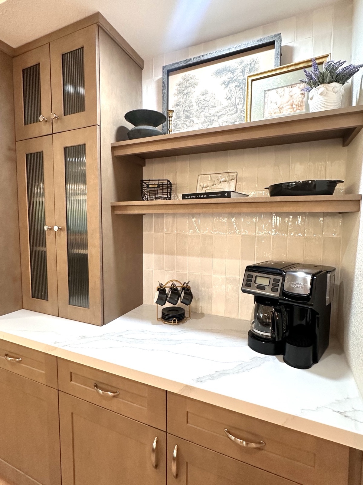 Coffee station with wood cabinets, open shelves, and a marble countertop