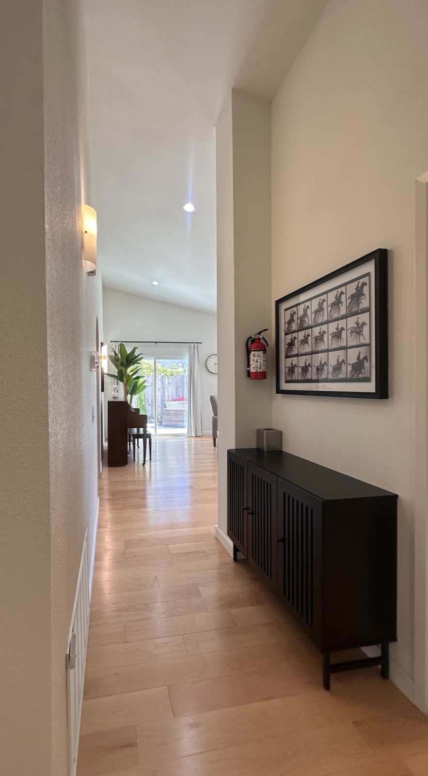 Bright interior hallway with a framed photo display and hardwood floors