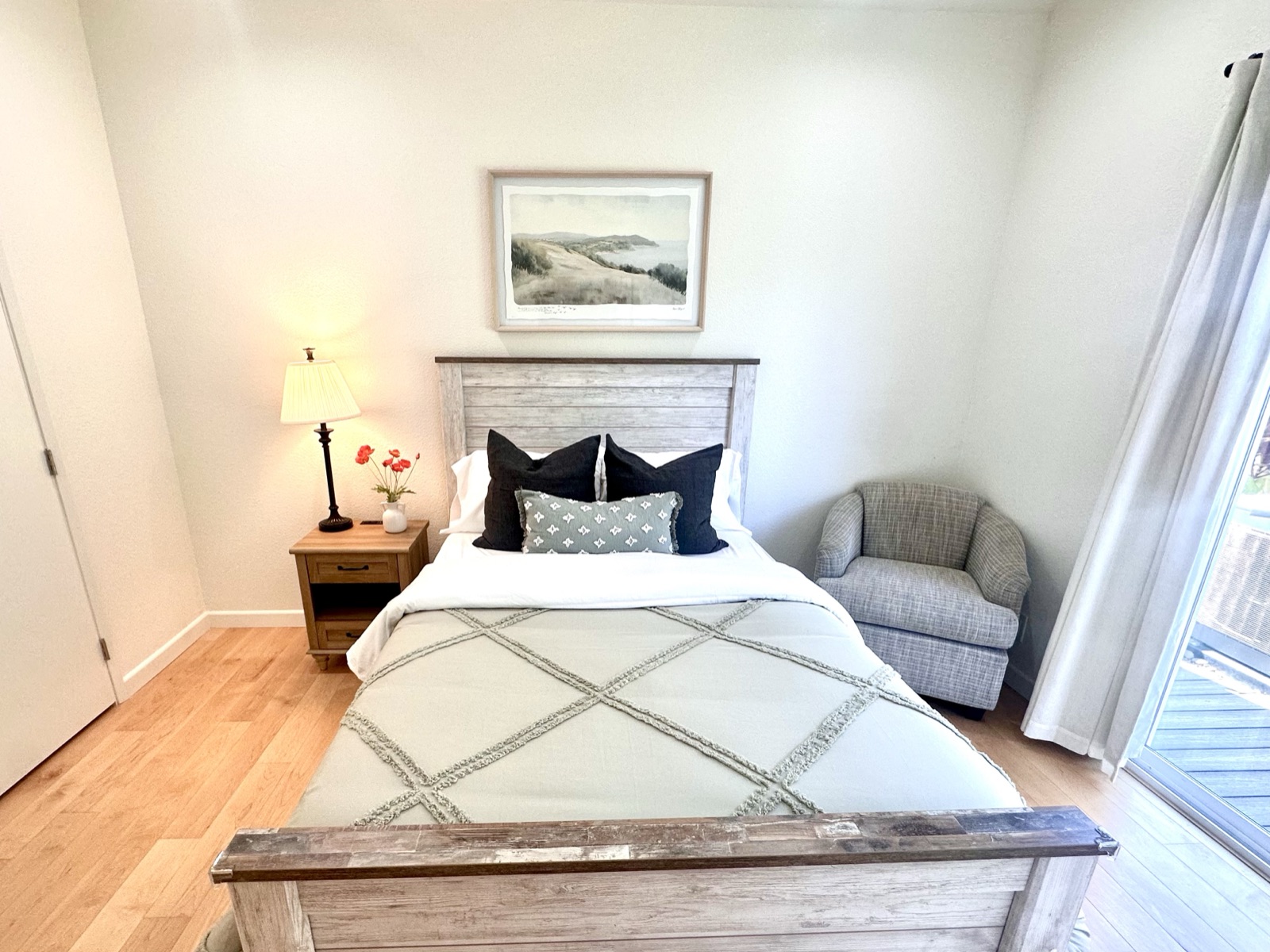 Private resident room with a lit bedside lamp, reading chair, and garden view