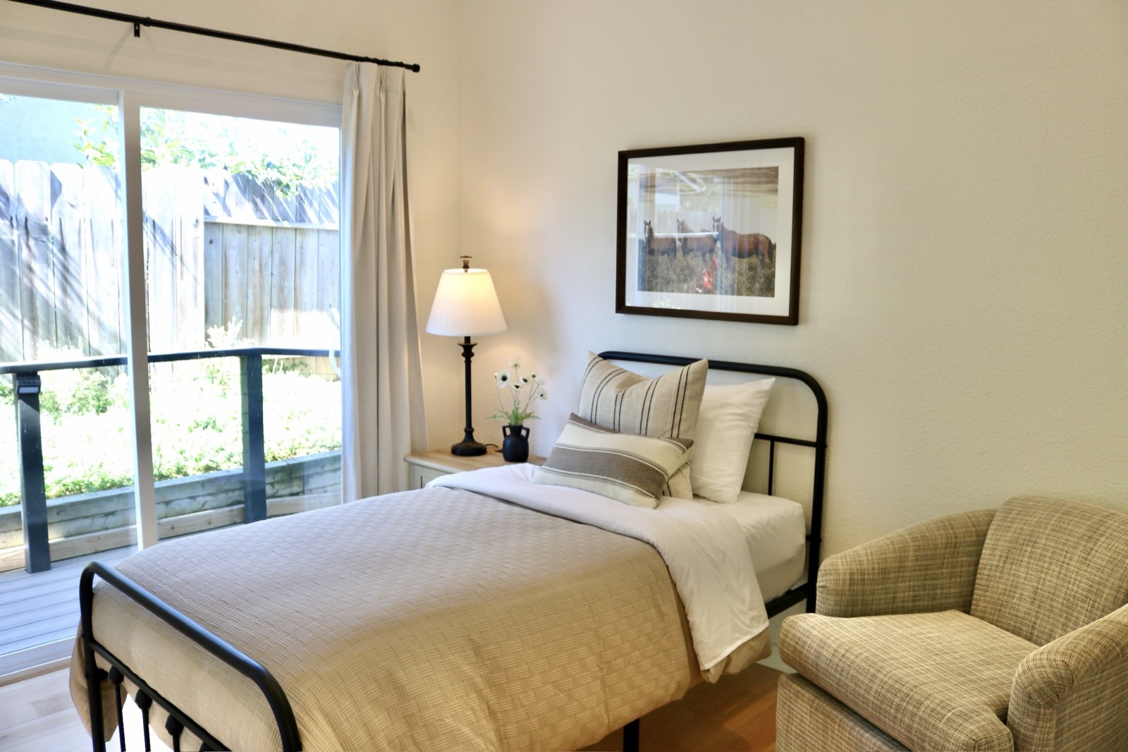 Private room with an iron bed frame and sliding door to the garden