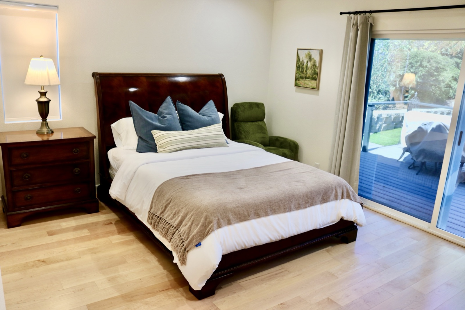 Master bedroom with a green accent chair and sliding door to the patio