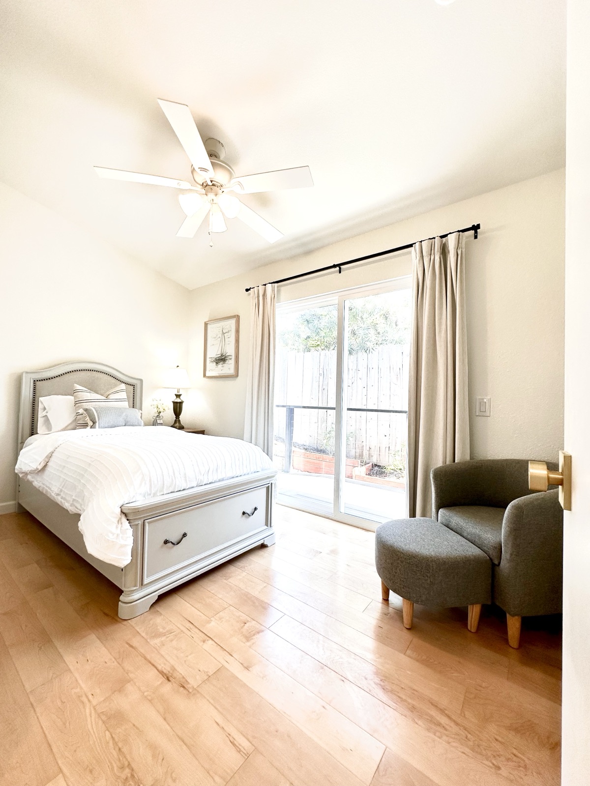 Private room warmly furnished with a lounge chair, ottoman, and patio access