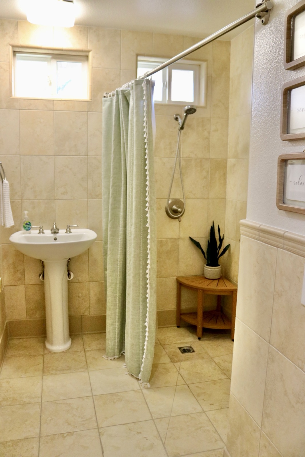 Accessible walk-in shower with grab bars, a handheld sprayer, and corner seat